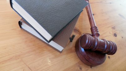 a wooden gavel laying on a table next to a stack of books