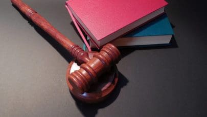 gavel and sounding block on desk next to books