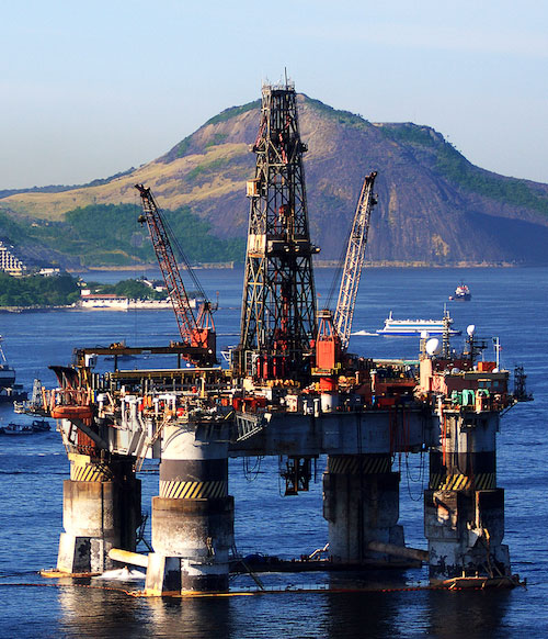 an offshore oil rig with mountains in the background